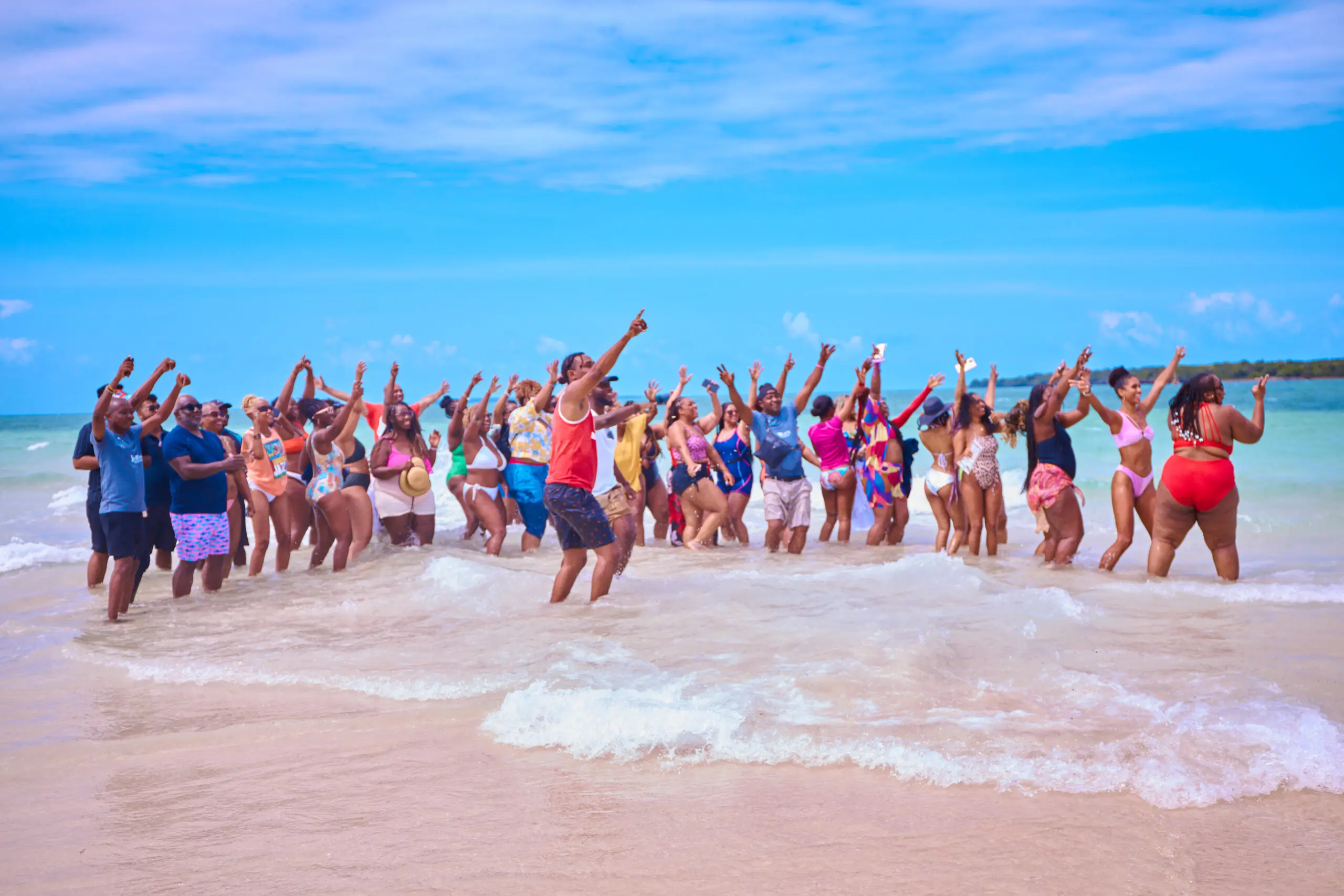 Black travel group celebrating together in the ocean on a JetBlack Travel group trip